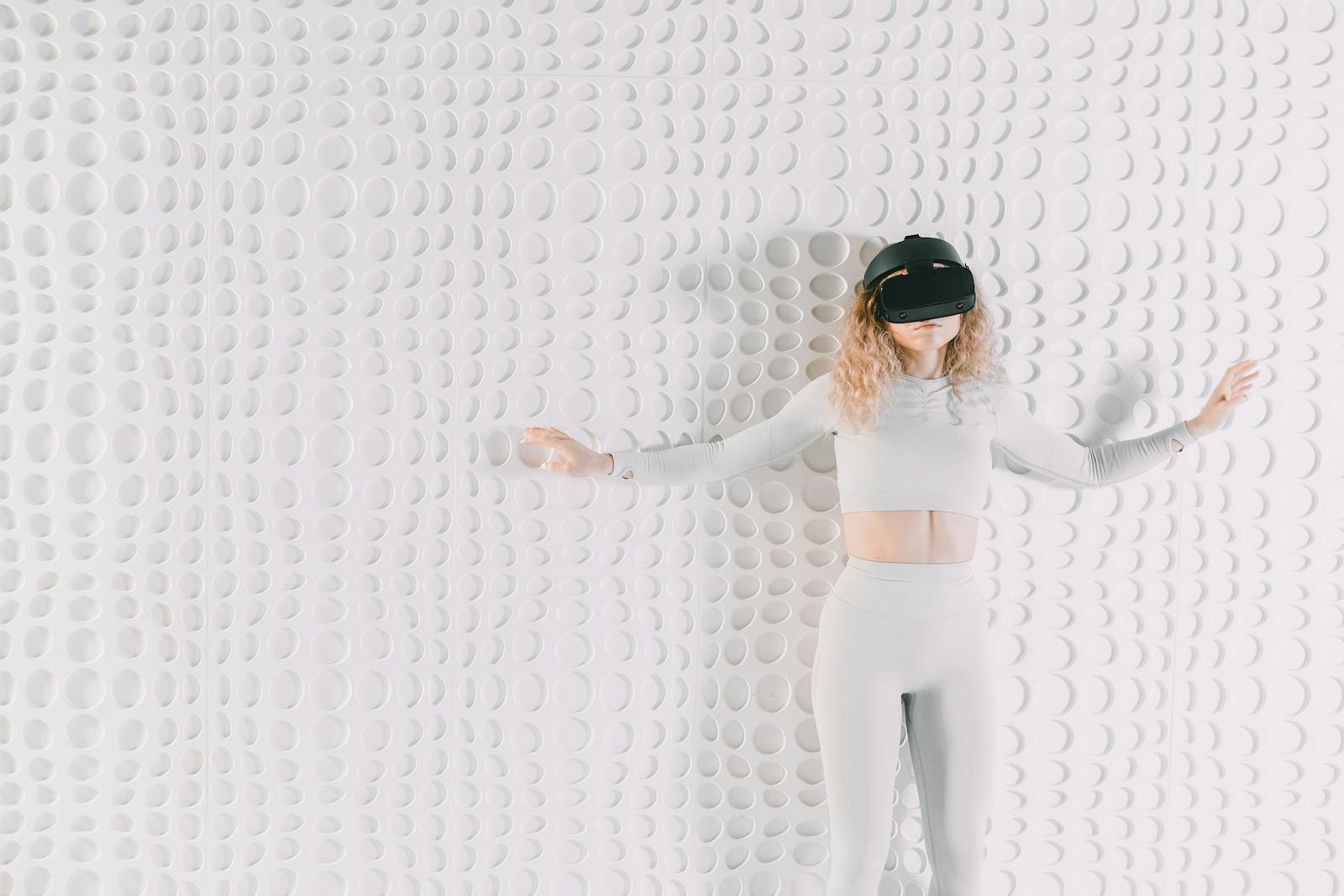 A woman immersed in virtual reality, wearing a VR headset against a textured wall.